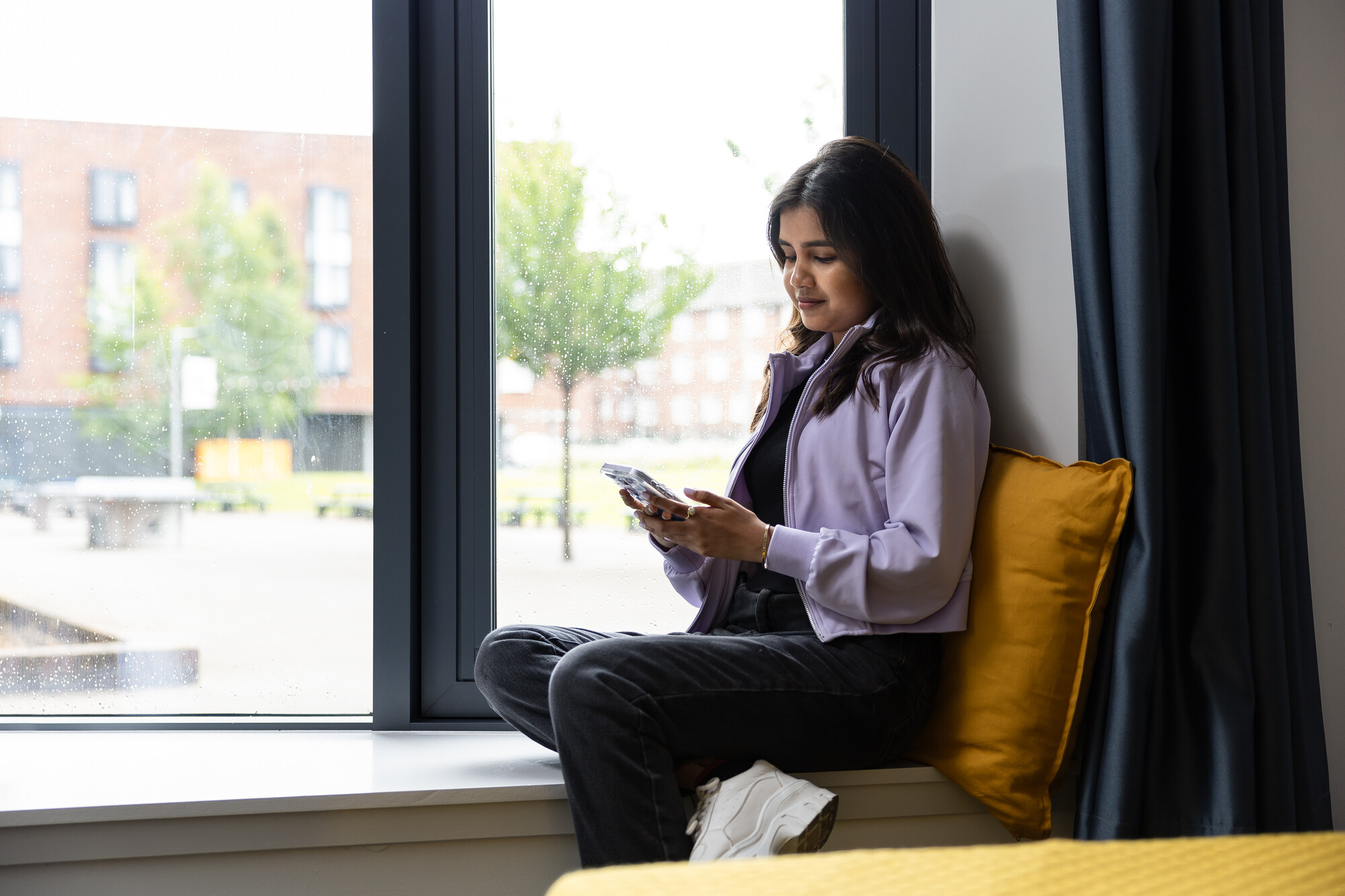 A student sat in the window of a student accommodation room